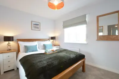 a bedroom with a large bed and a window at Lapwings, Aldeburgh in Aldeburgh