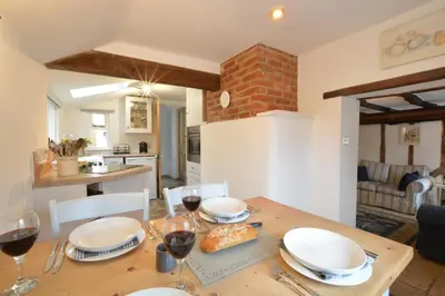 a dining room table with glasses of red wine at The Moorings, Orford in Orford