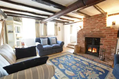 a living room with a couch and a fireplace at The Moorings, Orford in Orford