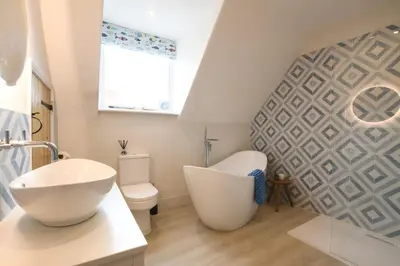 a bathroom with a white sink and a toilet at Arlo Cottage, Orford in Orford