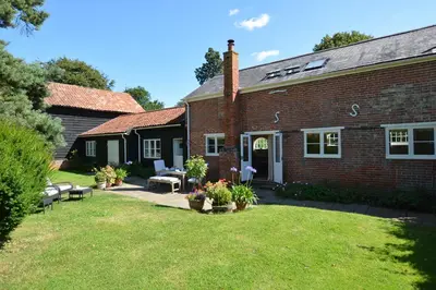 a brick house with a yard in front of it at Stable Cottage at the Grove, Great Glemham in Framlingham