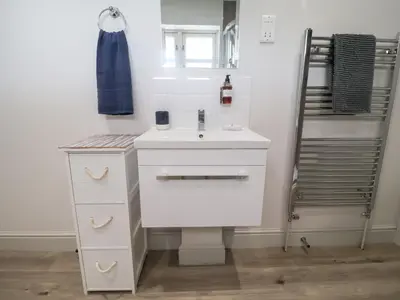 a bathroom with a white sink and a mirror at 1 Coconut Cottage, Long Melford in Long Melford
