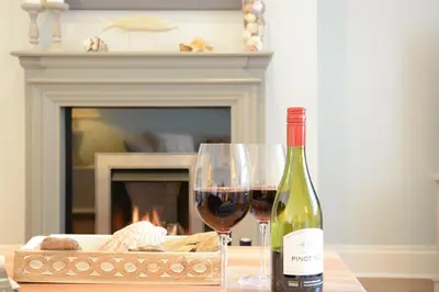 a bottle of wine and a glass on a table at High Tide, Crabbe Street, Aldeburgh in Aldeburgh