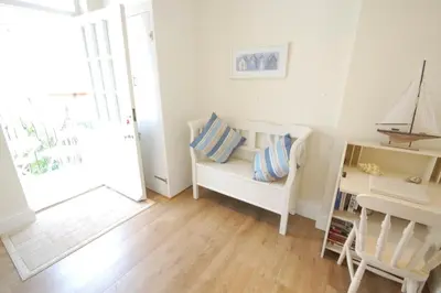 a white room with a white bench and a table at High Tide, Crabbe Street, Aldeburgh in Aldeburgh