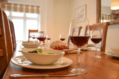 a table with glasses of wine and a bowl of food at Beresford House in Woodbridge