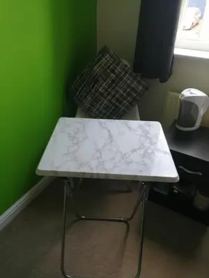 a white table in a green room with a chair at 59 Halstead - Gorgeous single bedroom with private bathroom in Halstead