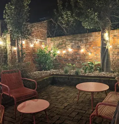 a patio with chairs and tables and lights at Arts House in Harwich
