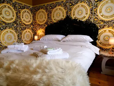 a bedroom with a large bed with towels on it at Deluxe 4 or 5 Bed House with Hot Tub, Cinema Room Sleeps 15 in Saffron Walden