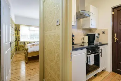 a kitchen with a sink and a stove at Deluxe 4 or 5 Bed House with Hot Tub, Cinema Room Sleeps 15 in Saffron Walden