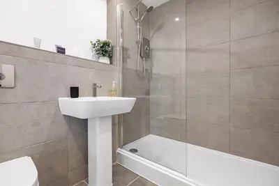 a bathroom with a sink and a shower and a toilet at Tailored Stays - Water Street Apartments in Cambridge
