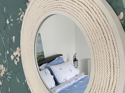 a mirror in a room with a bed in it at Lovely 1 bed flat 200 metres from beach in Walton-on-the-Naze