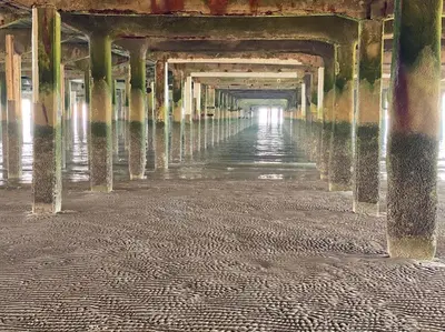 a long corridor of a pier with water in it at Lovely 1 bed flat 200 metres from beach in Walton-on-the-Naze