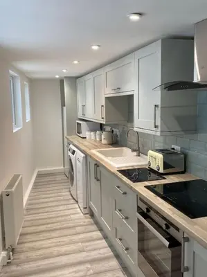 a kitchen with white cabinets and a counter top at Lovely 1 bed flat 200 metres from beach in Walton-on-the-Naze