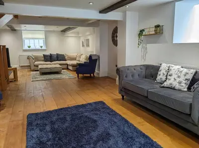 a living room with a gray couch and a blue rug at Beautiful Georgian townhouse in central Colchester in Colchester