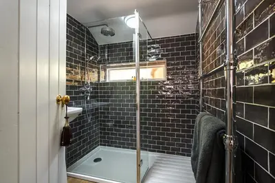 a bathroom with a shower with a glass door at Georgina in Lavenham