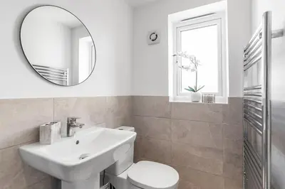 a white bathroom with a sink and a mirror at Modern Apartment in Wymondham in Wymondham