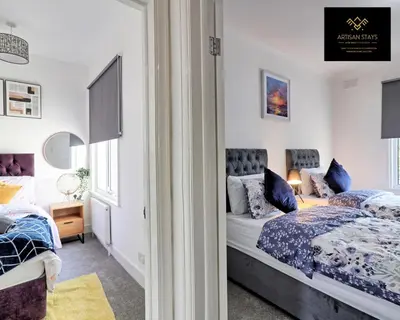 a bedroom with two beds and a window at Deluxe Apartment in Southend-On-Sea by Artisan Stays I Free Parking I Sleeps 4 in Southend-on-Sea