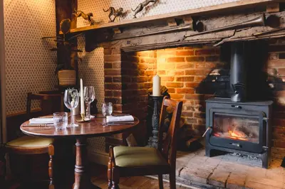 a table in a restaurant with a fireplace at The Crown, Bildeston in Bildeston