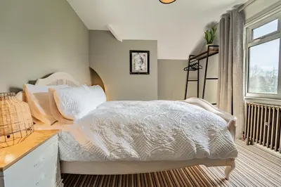 a bedroom with a white bed and a window at Suitable For Contractors 2 Double Beds and Sofa Bed Private Parking in Harlow