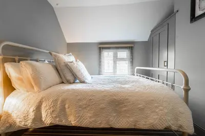 a bedroom with a bed with pillows and a window at Suitable For Contractors 2 Double Beds and Sofa Bed Private Parking in Harlow