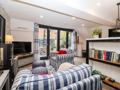 a living room with two couches and a tv at Tower End Cottage in Woodbridge