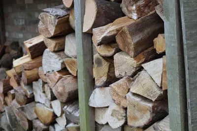 a pile of wood is stacked next to a wall at The Old Mill, 7 storey,, dog friendly outdoor pool & bbq in Stoke Ferry