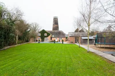 a large house with a green lawn in front of it at The Old Mill, 7 storey,, dog friendly outdoor pool & bbq in Stoke Ferry
