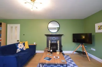 a living room with a blue couch and a fireplace at 11 Crabbe Street, Aldeburgh in Aldeburgh