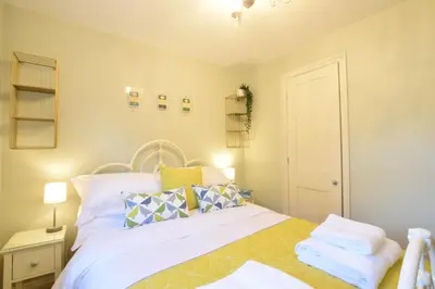 a bedroom with a bed with white sheets and pillows at 11 Crabbe Street, Aldeburgh in Aldeburgh