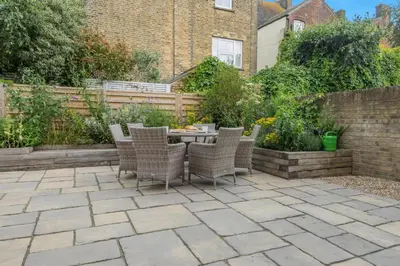 a patio with chairs and a table in a garden at 3 Bed in Aldeburgh oc-16afaw in Aldeburgh