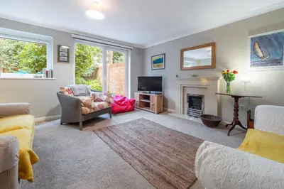 a living room with a fireplace and a tv at The Pines in Aldeburgh