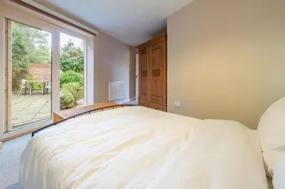 a bedroom with a large bed and a large window at The Pines in Aldeburgh