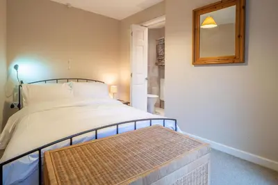 a bedroom with a large bed and a mirror at The Pines in Aldeburgh