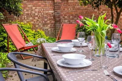 a table with plates and glasses and flowers on it at The Pines in Aldeburgh