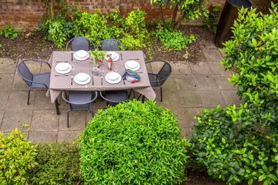an overhead view of a table and chairs in a garden at The Pines in Aldeburgh