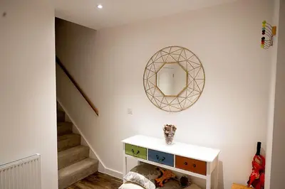 a bathroom with a mirror and a sink and stairs at Exquisite cozy house, close to Train Station and amenities in Harold Wood