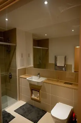 a bathroom with a sink and a shower and a toilet at Exquisite cozy house, close to Train Station and amenities in Harold Wood