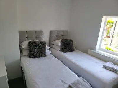 two beds sitting next to each other in a room at Vetrelax Southend Suites- Sleeps up to 5 - Free Wi-Fi - Contractors - Families- Free Parking- Long Term Stays in Southend-on-Sea
