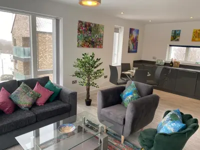 a living room with two couches and a glass table at Exquisite & Contemporary 2 Bed Apartment w Parking 10 mins walk to Papworth, Addenbrookes hospitals & Bio Medical Campus in Trumpington