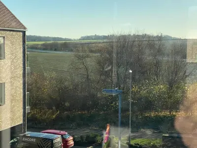 a window with a view of a field and a street light at Exquisite & Contemporary 2 Bed Apartment w Parking 10 mins walk to Papworth, Addenbrookes hospitals & Bio Medical Campus in Trumpington