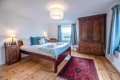 a bedroom with a bed and a dresser and a window at Solebay House, Tunstall in Woodbridge