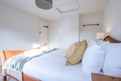 a white bedroom with two beds with pillows at Solebay House, Tunstall in Woodbridge