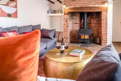 a living room with a couch and a fire place at Solebay House, Tunstall in Woodbridge