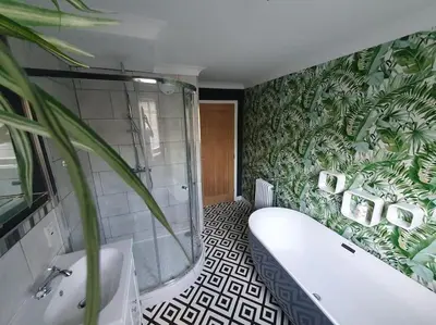 a bathroom with a tub and a green plant at Belle Vue Cottage in Downham Market