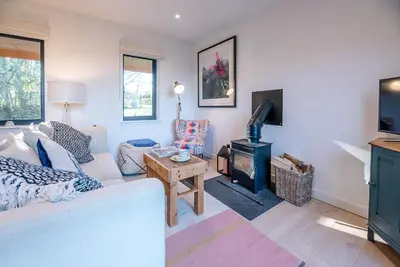 a living room with a couch and a stove at Little Bramble, Orford in Orford