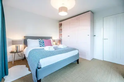 a bedroom with a blue and white bed in a room at Little Bramble, Orford in Orford