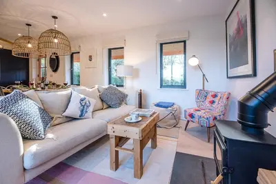 a living room with a couch and a table at Little Bramble, Orford in Orford