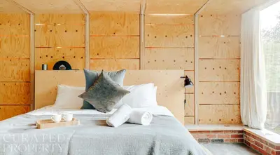 a bedroom with a bed with wooden walls at Grand Suffolk Barn Conversion in Chelsworth