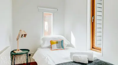 a white bedroom with a white bed and a window at Grand Suffolk Barn Conversion in Chelsworth
