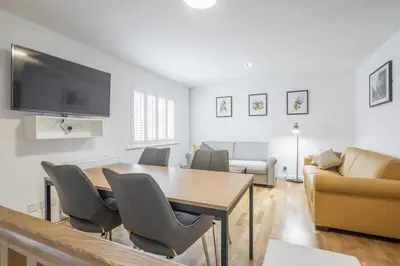 a living room with a table and chairs and a couch at Modern & Private - Free Parking in Cherry Hinton